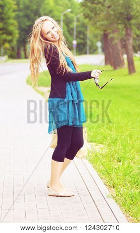 happy young woman laughing while standing on the footpath