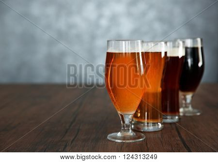 Glasses with different sorts of craft beer on wooden table