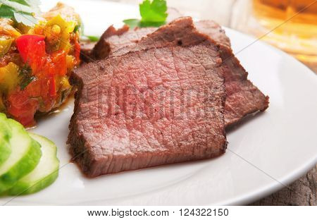 Delicious food. Pieces of roast beef on white plate