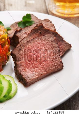 Pieces of roast beef on white plate. Delicious food