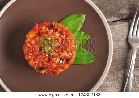 Healthy food . Vegetable stew in a brown plate on a wooden table closeup, top view