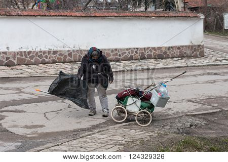 old homeless woman pushing a broken stroller