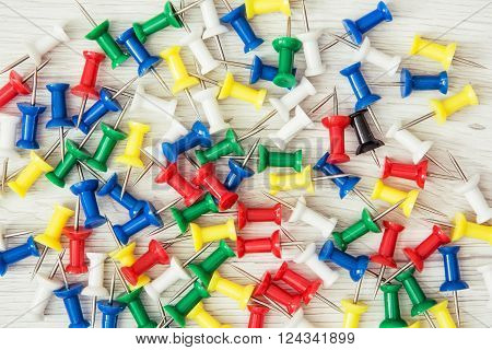 Background of coloured thumbtacks - office push pins. Office supplies.