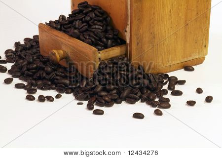 Kaffebönor i lådan av en antik Grinder