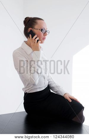Business woman looking at her smartphone and checking her mails in the city