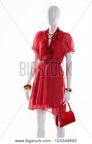 Bright red dress on mannequin. Female mannequin in fashionable dress. Short ripple dress for summer. Woman's red outfit with accessories.