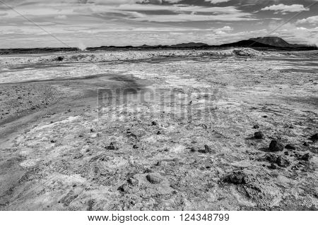 Mudpot in the geothermal area Hverir, Iceland. The area around the boiling mud is cracked. 