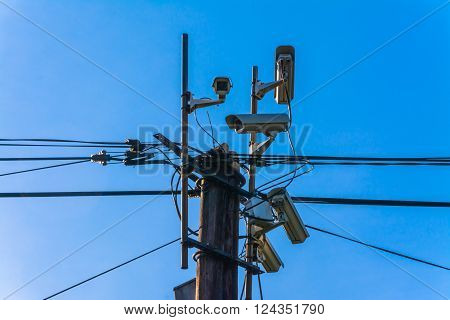 security camera on wooden pole in town