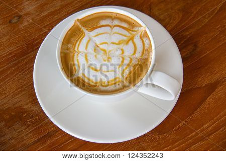 White cup of cappuccino coffee on wood background
