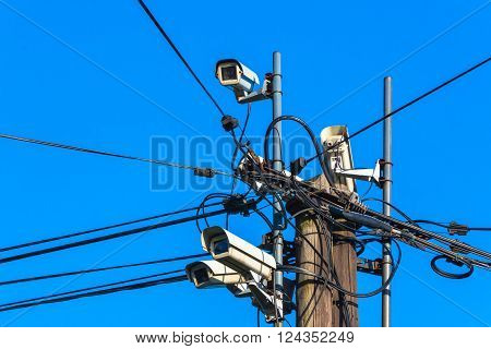security camera on wooden pole in town