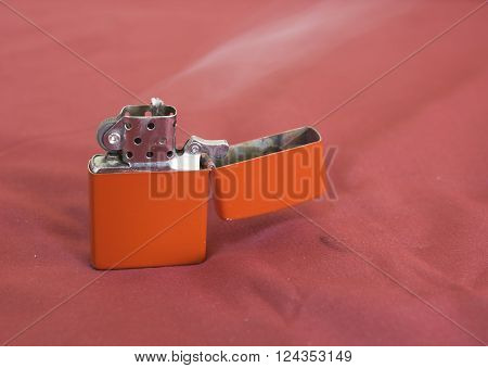 red gasoline lighter with flame on red background