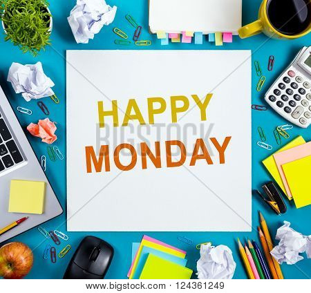 Happy Monday. Office table with notepad, computer and coffee cup on blue background. Business creative consept top view