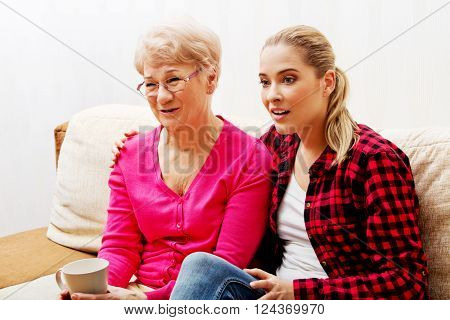 Mother with adult daughter watching sad movie
