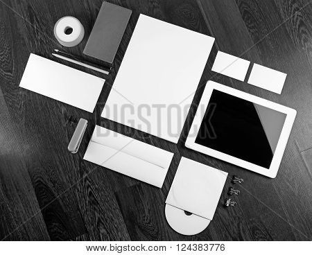 Photo of blank corporate identity template on dark wooden background. Blank stationery for design presentations and portfolios. ID template. Black and white image.