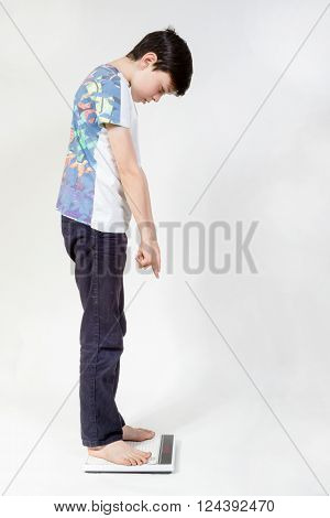 Young boy looking at how much he weighs
