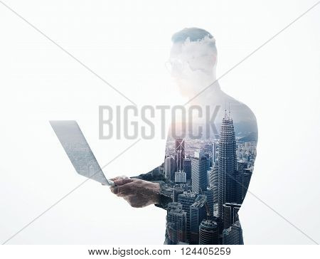 Double exposure bearded businessman wearing black suit and glasses.Banker holding contemporary notebook hands.Work online banking.Isolated white, modern skyscraper city background.