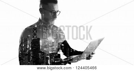 Double exposure bearded businessman wearing black shirt and glasses.Banker holding contemporary notebook hands, online banking.Isolated white, modern skyscraper city at night background