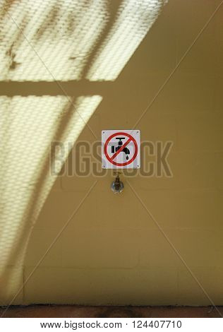 Water faucet underneath Non potable sign on wall.