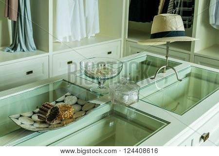 white hat and jewelry set on a dresser table in a contemporary room.