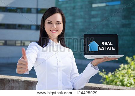 buy or rent - beautiful business woman holding laptop with real estate application