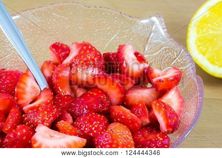 cut strawberries macerated in lemon in a glass cup
