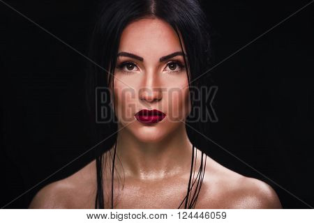 Beautiful youngwoman on black background. Closeup portrait of young beautiful