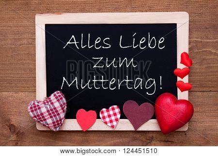 Blackboard With German Text Alles Liebe Zum Muttertag Means Happy Mothers Day. Red Textile Hearts. Wooden Background With Vintage, Rustic Or Retro Style.