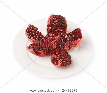 Split open flower served on the white ceramic plate pomegranate Punica granatum fruit isolated over the white background