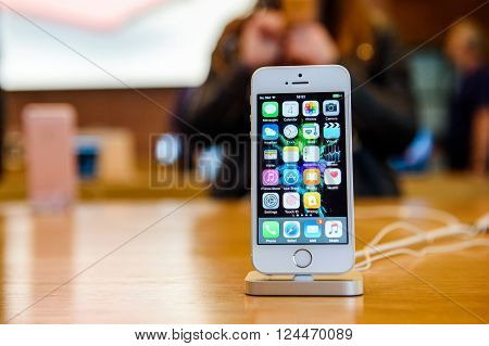 PARIS FRANCE - APR 4 2016: People testing new iPhone with the Apple iPhone SE in docking station during the sales launch of the latest Apple Inc. smartphone and iPad Pro at the Apple store in Paris France
