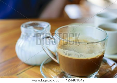 Morning cup of hot coffee with cream on table