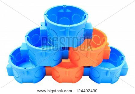 Stack of blue and orange plastic electrical boxes on white background junction boxes accessories for engineering jobs