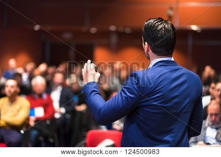 Speaker giving a talk on corporate Business Conference. Audience at the conference hall. Business and Entrepreneurship event.