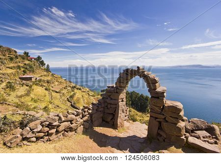 arch above titicaca lake in peru with blue sky