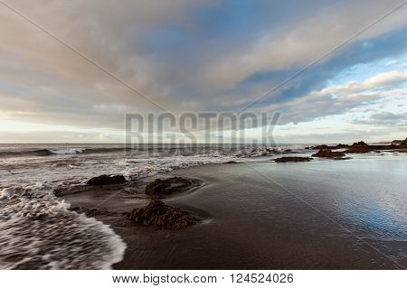 Summer sunrise seascape on tropical island Tenerife, Canary in Spain. Playa de La Tejita beach view on atlantic ocean and Punta Roja rock.