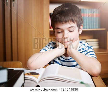 seven years old child reading a book at home