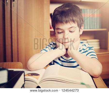 seven years old child reading a book at home