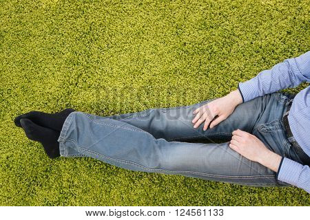 young man sitting on a green carpet with tablet