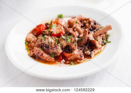 Fresh boiled galician style octopus served with olive oil red pepper and parsley in local restaurant in Taganana on tropical island Tenerife Canary in Spain. Spanish food specialities.