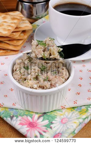 Appetizer of fish paste (forshmak) into a bowl on a tray with a cup of coffee