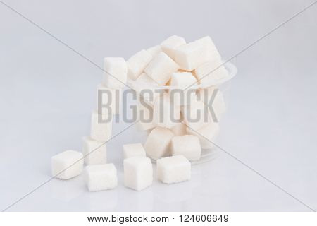 refined sugar in the plastic Cup on white background