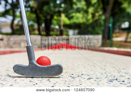 Closeup of red mini golf ball. Strike concept.