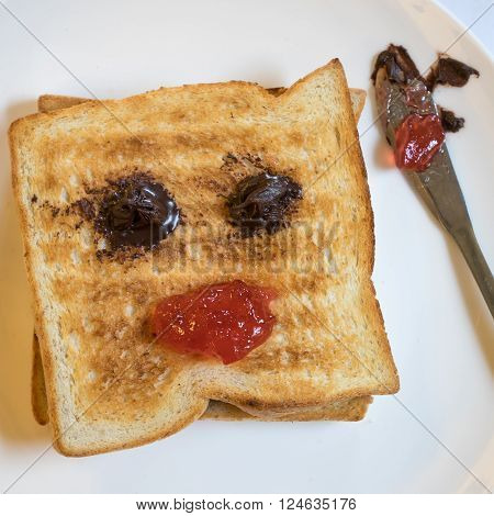 The close up of tasty bread toast and strawberry jam with chocolate spread on white plate.