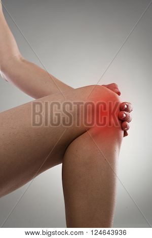 Woman touching her knee in pain. Gout or arthritis concept.