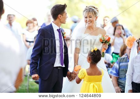 Happy emotional bride during the wedding ceremony among crowd of  guests, outdoors. Ceremonial part, vows.