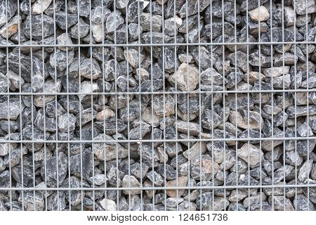 Gabion filled with thick stones; Metal Stone basket with large natural stones for external landscaping.