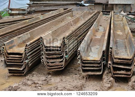 MALACCA, MALAYSIA -SEPTEMBER 25, 2015: Stack of retaining wall steel sheet pile cofferdam lay on ground at the construction site in Malaysia