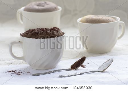 Chocolate cakes in a coffee mug and two tablespoons of cocoa and sugar.