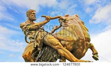 Schwerin, Germany - June 13, 2012: medieval hero statue fighting with a bull Schwerin castle garden landmark in the city of Schwerin in northern Germany