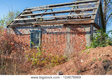 An old abandoned brick house with a broken window, closeup. As background for design of crisis.