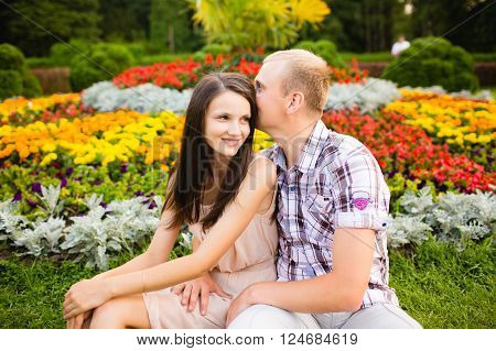 Cute teen couple lovely hugging in the garden flowers.